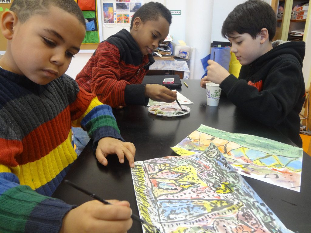 A group of children are sitting at a table making art.