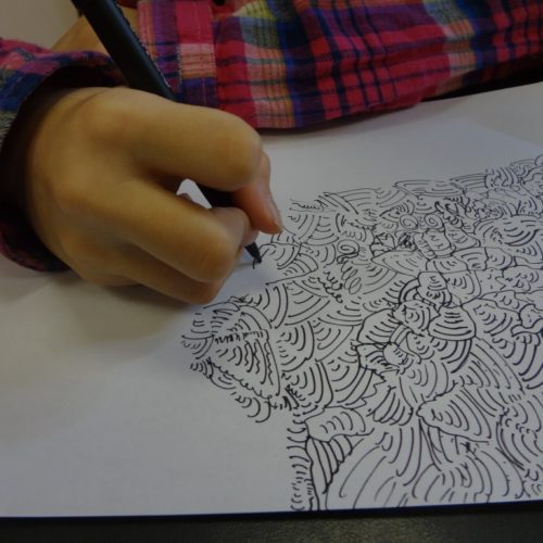 A child is drawing on a piece of paper.