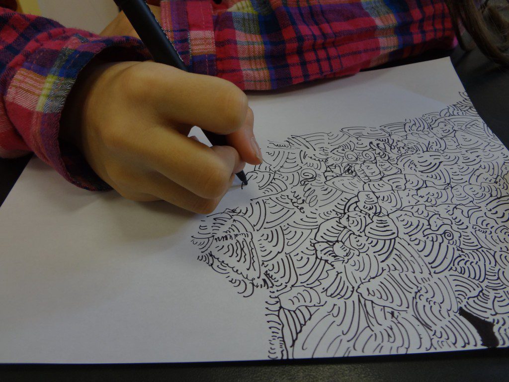 A child is drawing on a piece of paper.