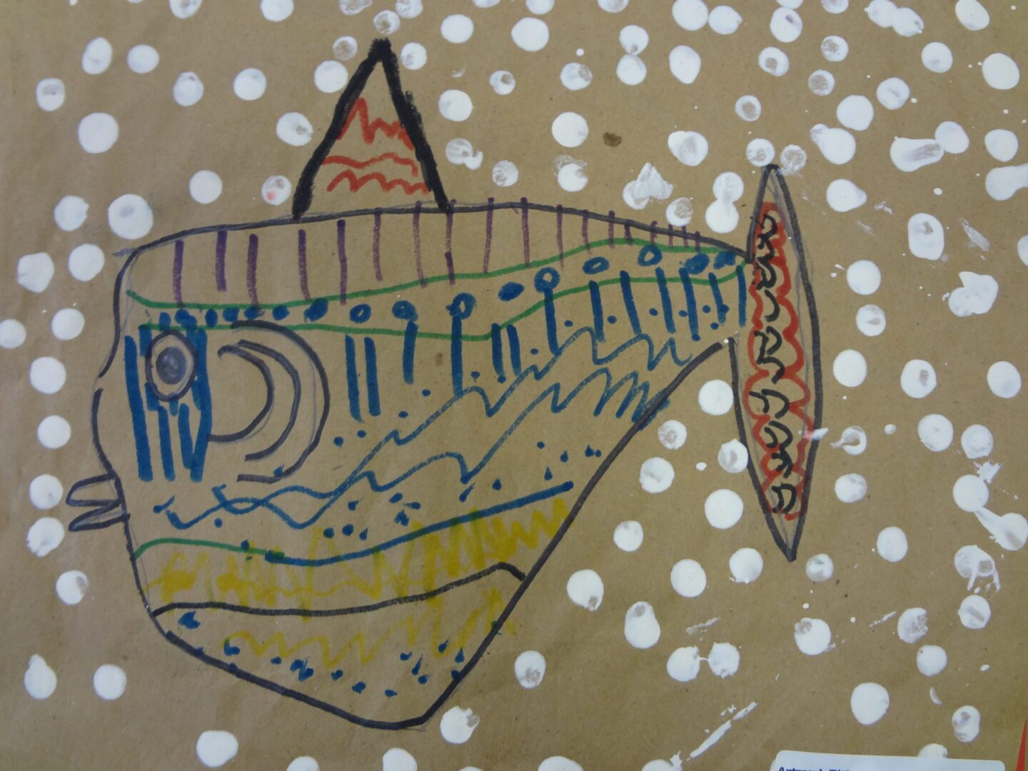 A drawing of a fish on brown paper.