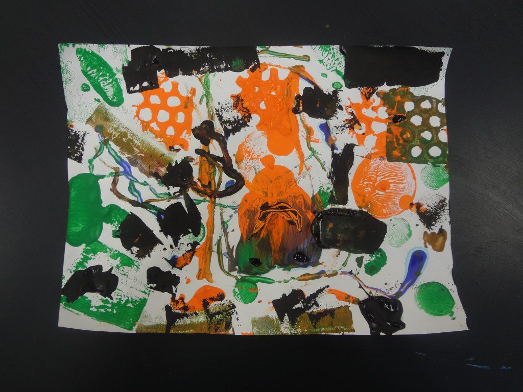 An orange, green, and black painting on a table.