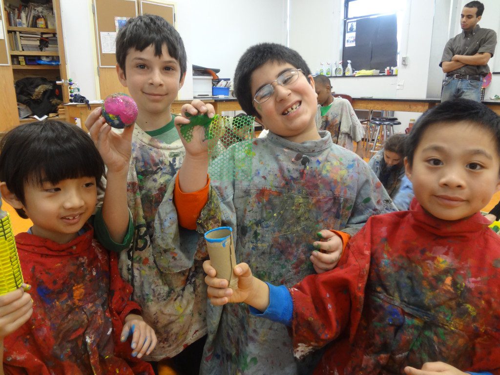A group of kids in a classroom with paint on their faces.