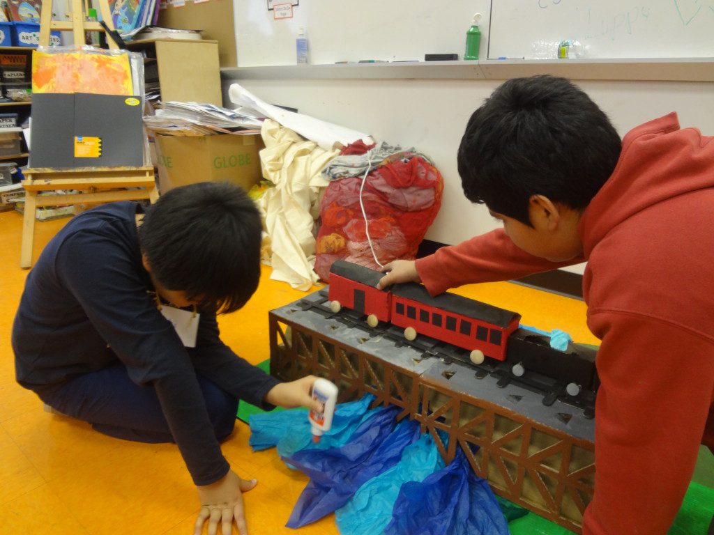 Two boys playing with a toy train.