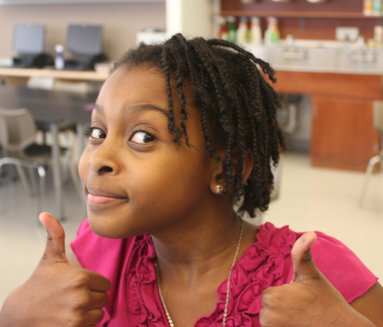 A girl giving a thumbs up.