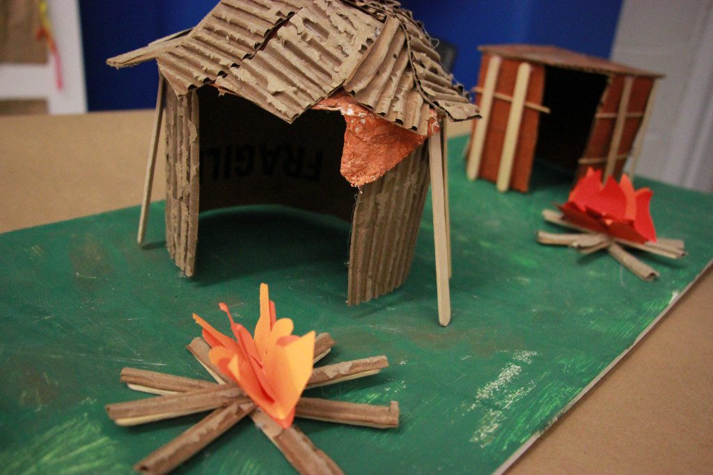 A model of a hut with a fire in the middle.