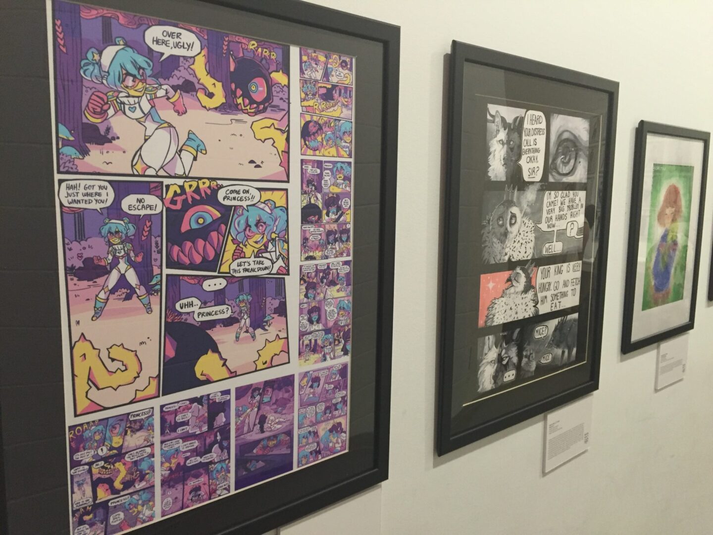 Framed comic strips on display in an art gallery.