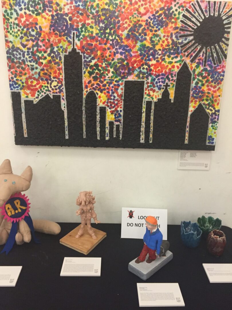 A display of sculptures and paintings on a table.