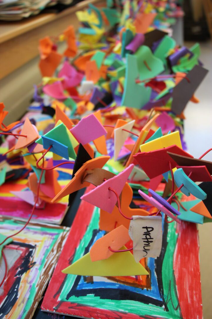 A group of colorful paper sculptures on a table.