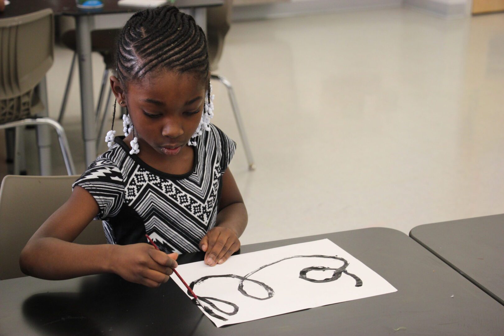 A young girl drawing on a piece of paper.