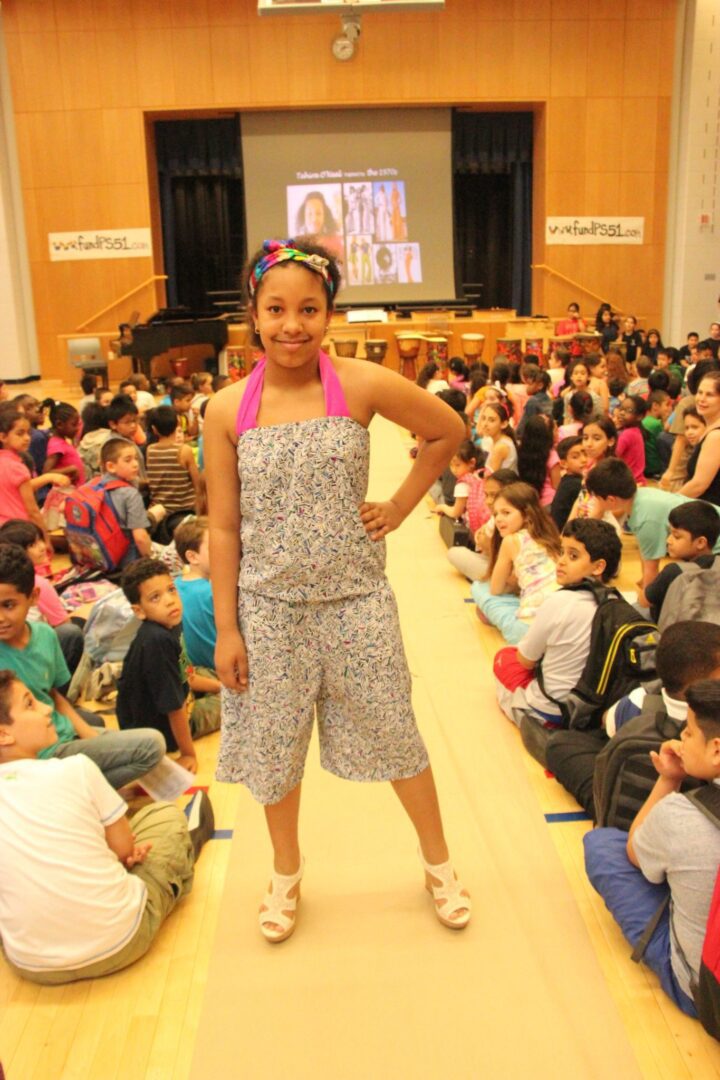 A girl standing in front of a crowd of people.