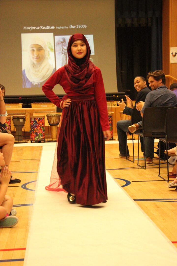 A girl in a hijab walking down a runway.