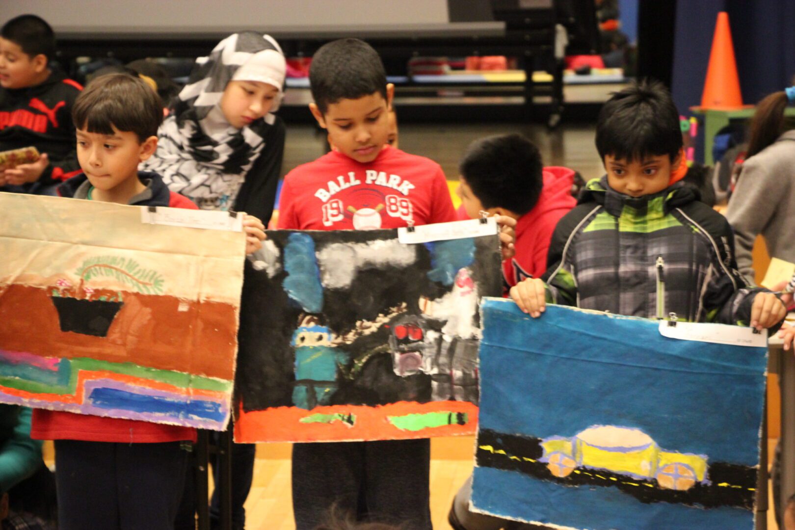 A group of kids holding up their artwork.