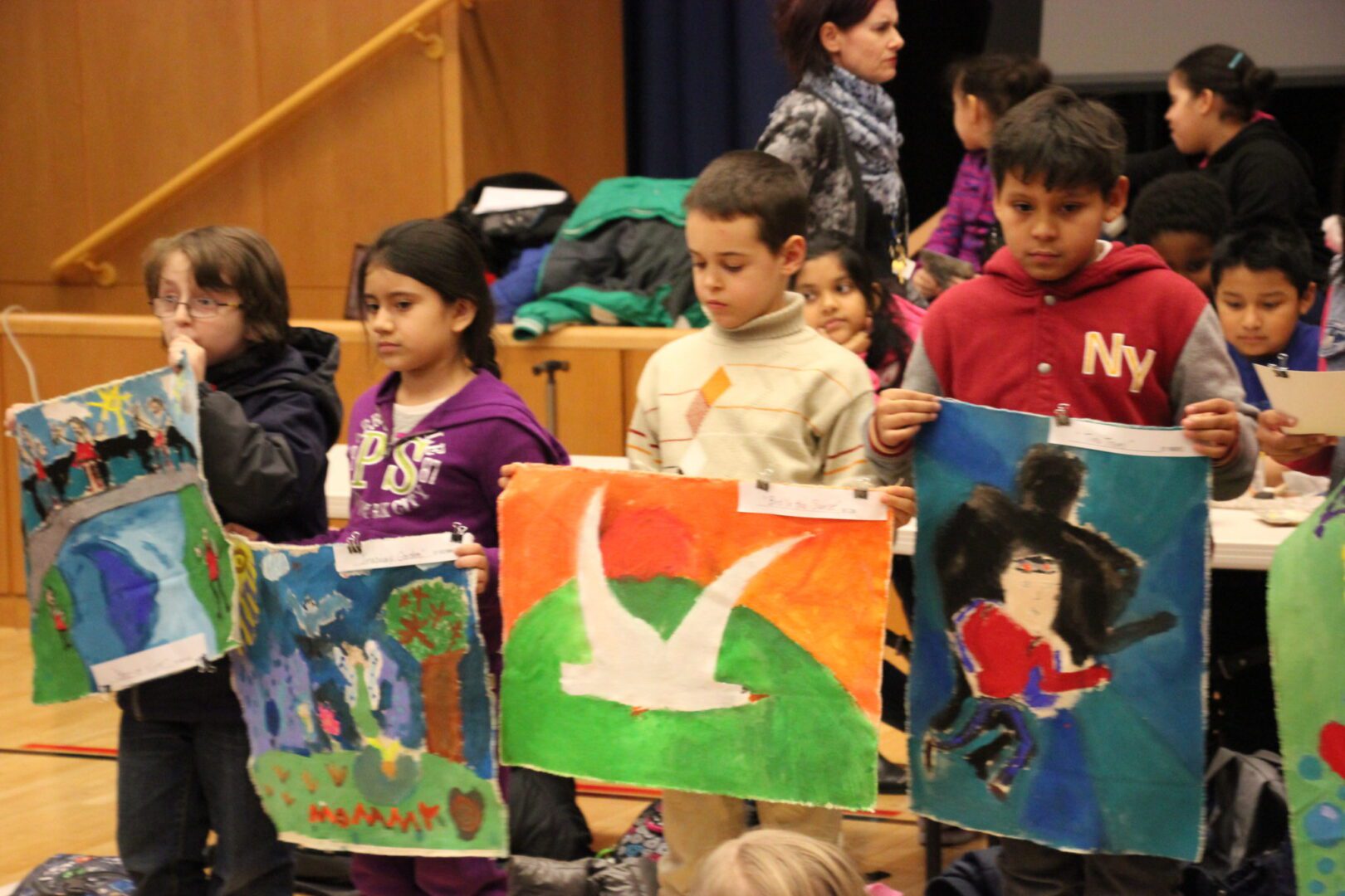 A group of children holding up paintings.