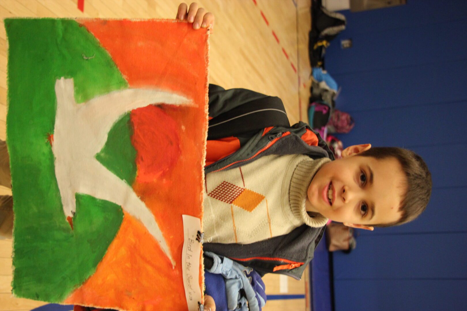 A young boy holding up a flag.