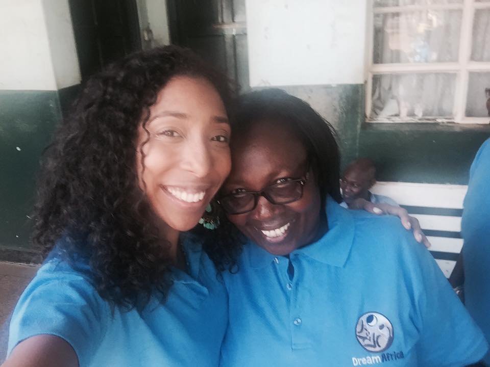 Two women in blue shirts posing for a photo.
