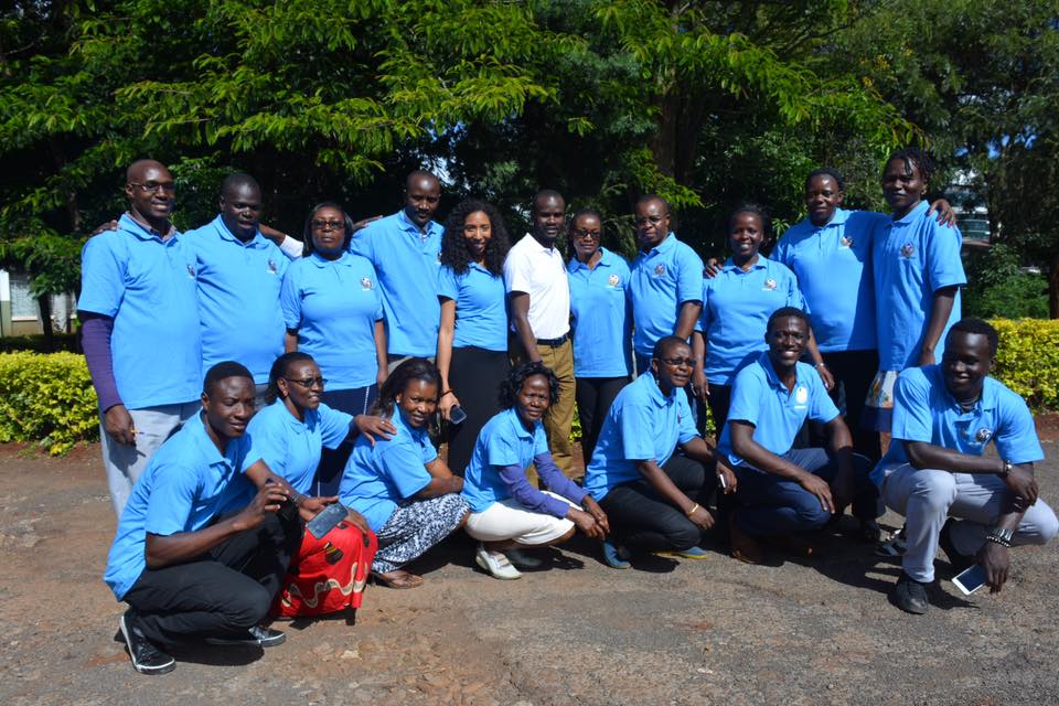 A group of people in blue shirts posing for a photo.