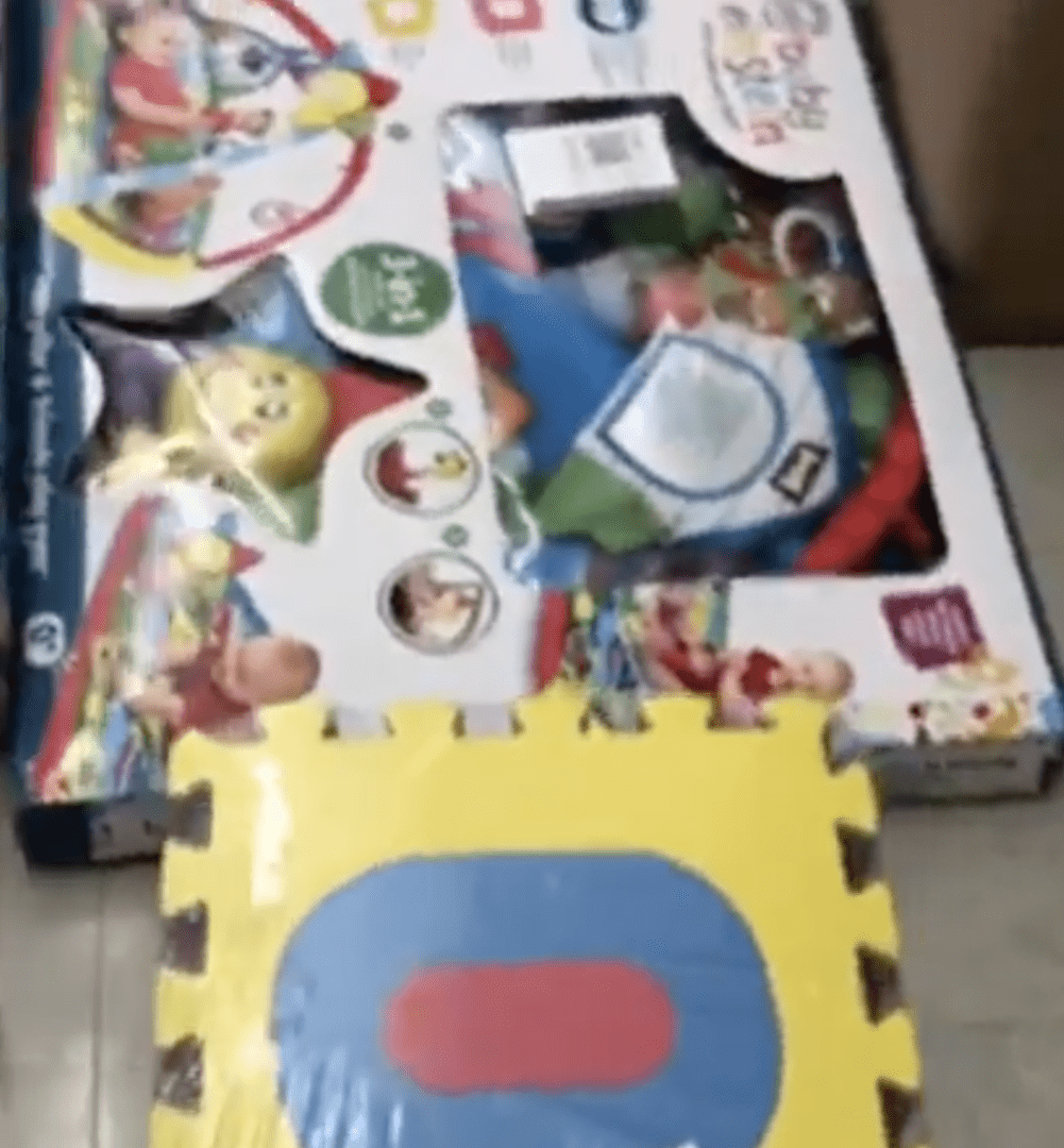 A box with a toy and a mat in it.