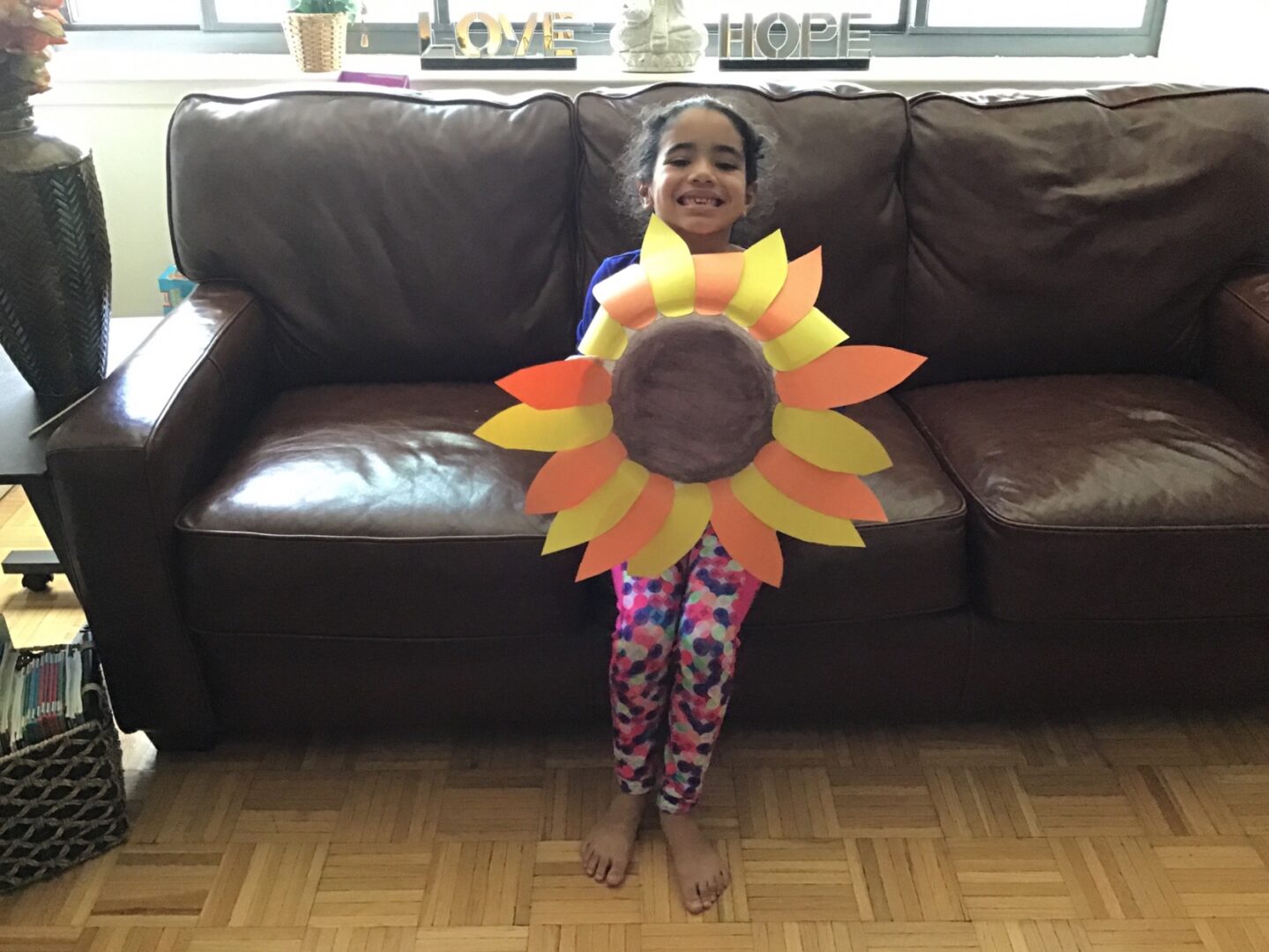 Toddler holding a paper sunflower art