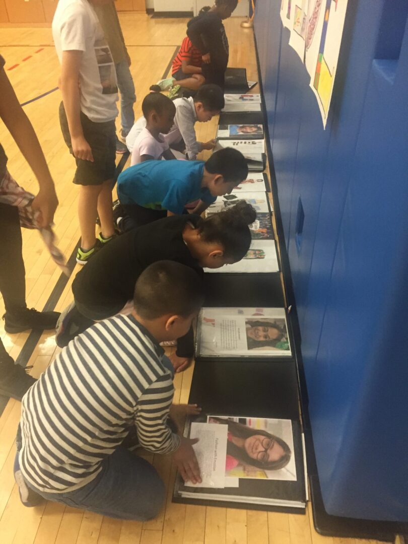 A group of children looking at pictures in a gym.