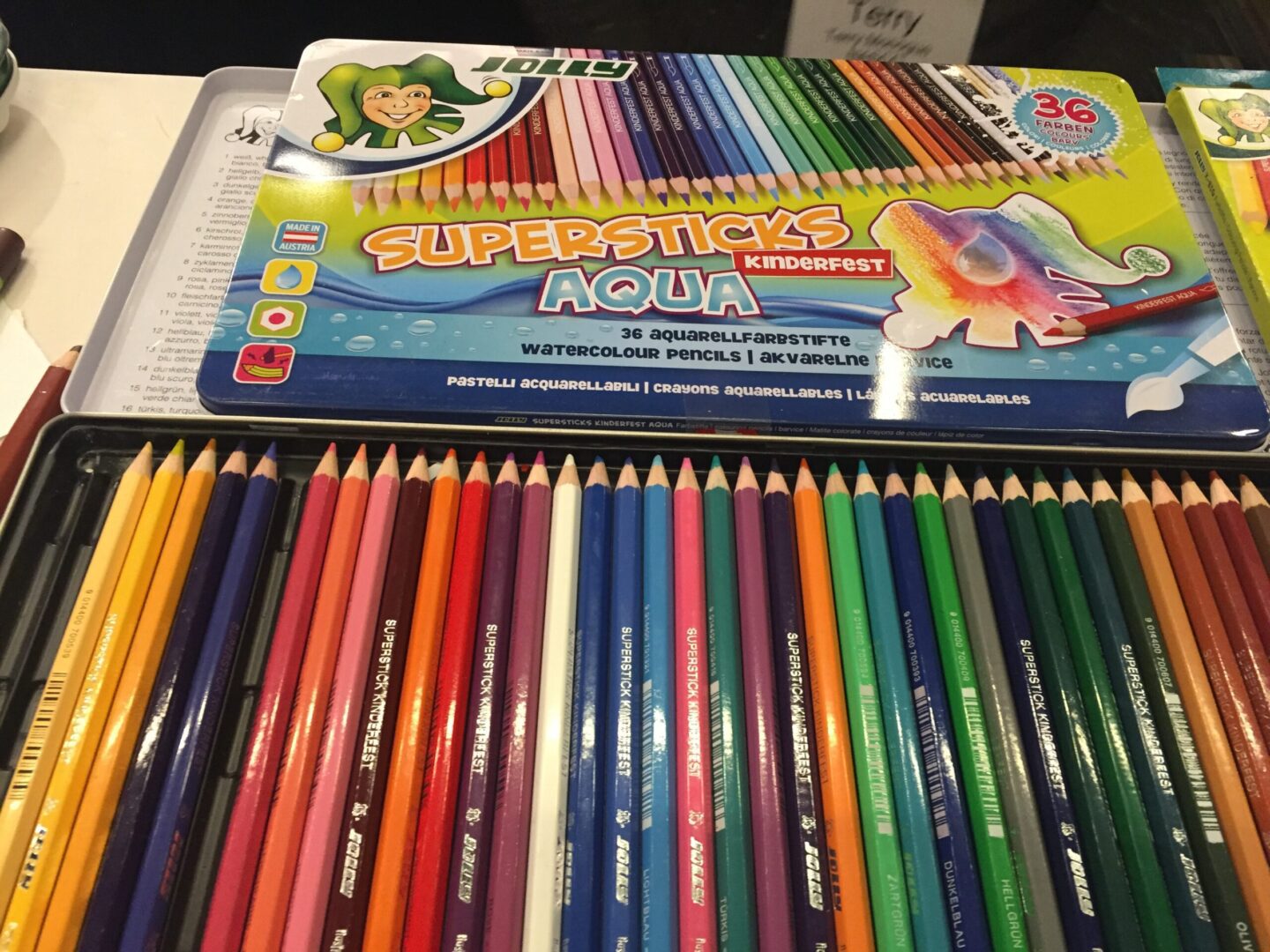 A tin of colored pencils on a table.